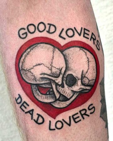 black and red tattoo on the arm on the forearm heart and 2 skulls and the inscription good lovers dead lovers