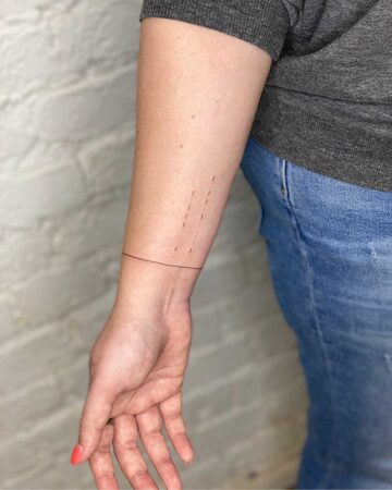 black and white tattoo on the arm on the wrist thin lines bracelet around the arm minimalism inscription in Morse Morse code