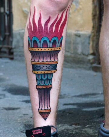 Colorful torch tattoo with flames on a person's shin Done by tattoo artists in our fine line tattoo studio parlour shop Canggu, Bali
