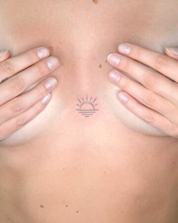 Small sun tattoo between hands on bare skin Done by tattoo artists in our fine line tattoo studio parlour shop Canggu, Bali