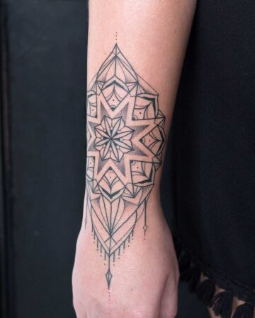 tattoo pattern on the arm on the wrist with access to the brush black and white fine lines geometric elements graphics