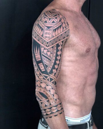 Man with intricate tribal polinesian sleeve tattoo on upper arm Done by tattoo artists in our fine line tattoo studio parlour shop Canggu, Bali