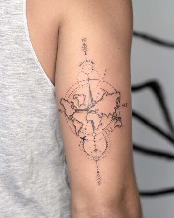 A minimalist world map tattoo on an arm, featuring a compass design and a small airplane. This travel tattoo design incorporates a detailed world map, a compass pointing north, and a stylized airplane, perfect for those dreaming of travel. The design is a great example of a minimalist travel tattoo. Done by tattoo artists in our fine line tattoo studio parlour shop Canggu, Bali