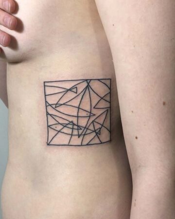 A geometric abstract tattoo on the ribcage featuring a square frame filled with intersecting lines and shapes. This minimalist tattoo is an example of abstract tattoo art, a popular choice for rib tattoos. Done by tattoo artists in our fine line tattoo studio parlour shop Canggu, Bali