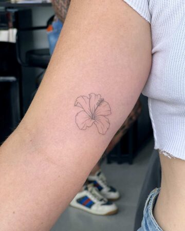 tattoo fineline hibiskus on the hand woman thin line fine line black single needle minimalistic on the arm