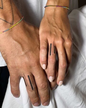 Matching minimalist finger tattoos for a couple, symbolizing connection. By tattoo artists in tattoo studio Canggu, Bali