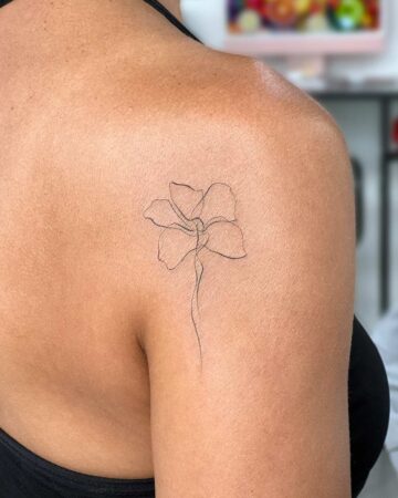 Minimalist line art flower tattoo on a shoulder. Simple flower tattoo idea. By tattoo artists in tattoo studio Canggu, Bali