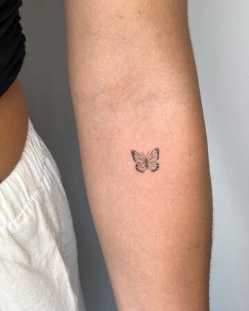 Small butterfly tattoo on an arm, minimalist design. By tattoo artists in tattoo studio Canggu, Bali