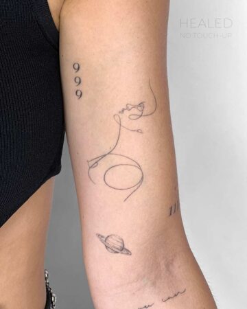Delicate fine line tattoos on an arm, including the numbers 999, a minimalist line drawing of a face, a small planet with rings, and the number 111. "Healed, No Touch-Up" text is present. Done by tattoo artists in our fine line tattoo studio parlour shop Canggu, Bali