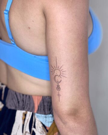 Minimalist celestial tattoo on a woman's arm, featuring a sun, crescent moon, and star design. A perfect tattoo for celestial lovers. Done by tattoo artists in our fine line tattoo studio parlour shop Canggu, Bali