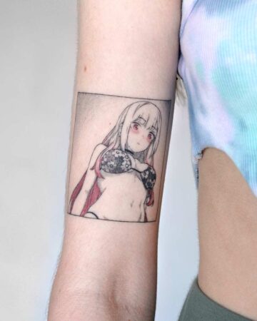 Anime tattoo of a manga-style character on an arm. The tattoo features a woman in a bikini with long hair, framed within a rectangle. This anime art tattoo is a cool tattoo idea. Done by tattoo artists in our fine line tattoo studio parlour shop Canggu, Bali