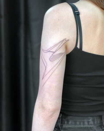 Minimalist line art tattoo of an abstract straight geometric form on a woman's upper arm. This tattoo gallery page showcases the best tattoo artists in Canggu, Bali for unique designs.