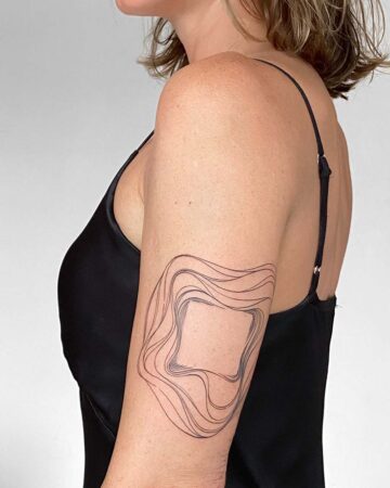 Woman's arm with a minimalist abstract tattoo design featuring wavy lines around a central square. The tattoo is an example of modern body art. Done by tattoo artists in our fine line tattoo studio parlour shop Canggu, Bali