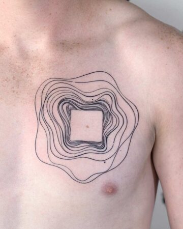 A minimalist geometric tattoo on a person's chest, featuring a square within concentric, wavy lines. The black ink design evokes a topographic map, showcasing a unique chest tattoo concept. Done by tattoo artists in our fine line tattoo studio parlour shop Canggu, Bali