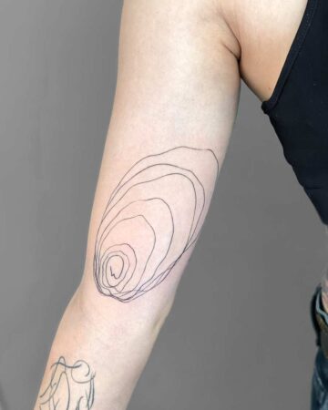 Minimalist line art tattoo on an arm, featuring an abstract design of concentric curves. This arm tattoo is a great example of a minimalist tattoo style. done by artists in our fine line tattoo studio Canguu Bali