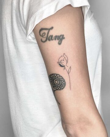 Arm with floral and name tattoos on upper bicep Done by tattoo artists in our fine line tattoo studio parlour shop Canggu, Bali