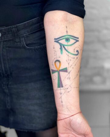 color tattoo with geometric elements on the arm on the forearm thin lines geometry of the eye of Horus and the Egyptian key