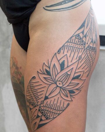 Lotus flower tattoo on a person's thigh with intricate geometric patterns Done by tattoo artists in our fine line tattoo studio parlour shop Canggu, Bali