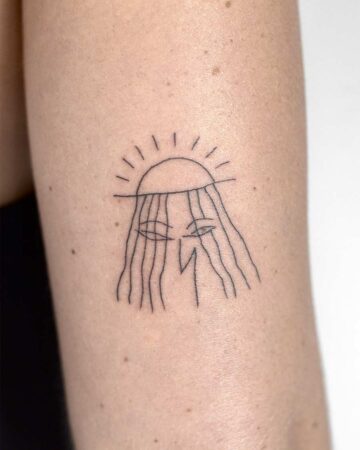 Minimalist fine line tattoo of a stylized face with sun rays, delicate black ink on arm. Small tattoo design, perfect for minimalist tattoo ideas. Done by tattoo artists in our fine line tattoo studio parlour shop Canggu, Bali