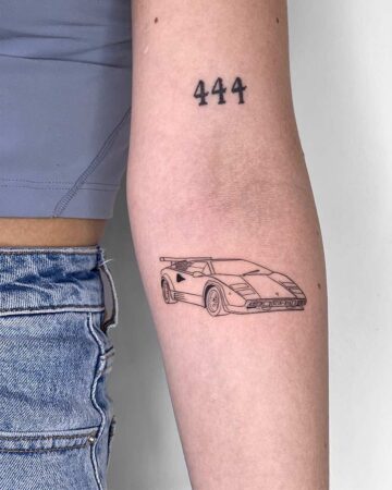 Minimalist Lamborghini Countach car tattoo on an arm, with the numbers "444" above it. A cool car tattoo idea, perfect for fans of the iconic sports car. Done by tattoo artists in our fine line tattoo studio parlour shop Canggu, Bali