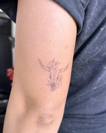 tattoo fineline on the hand thin line bull skull flowers star fine line black single needle minimalistic on the arm above elbow