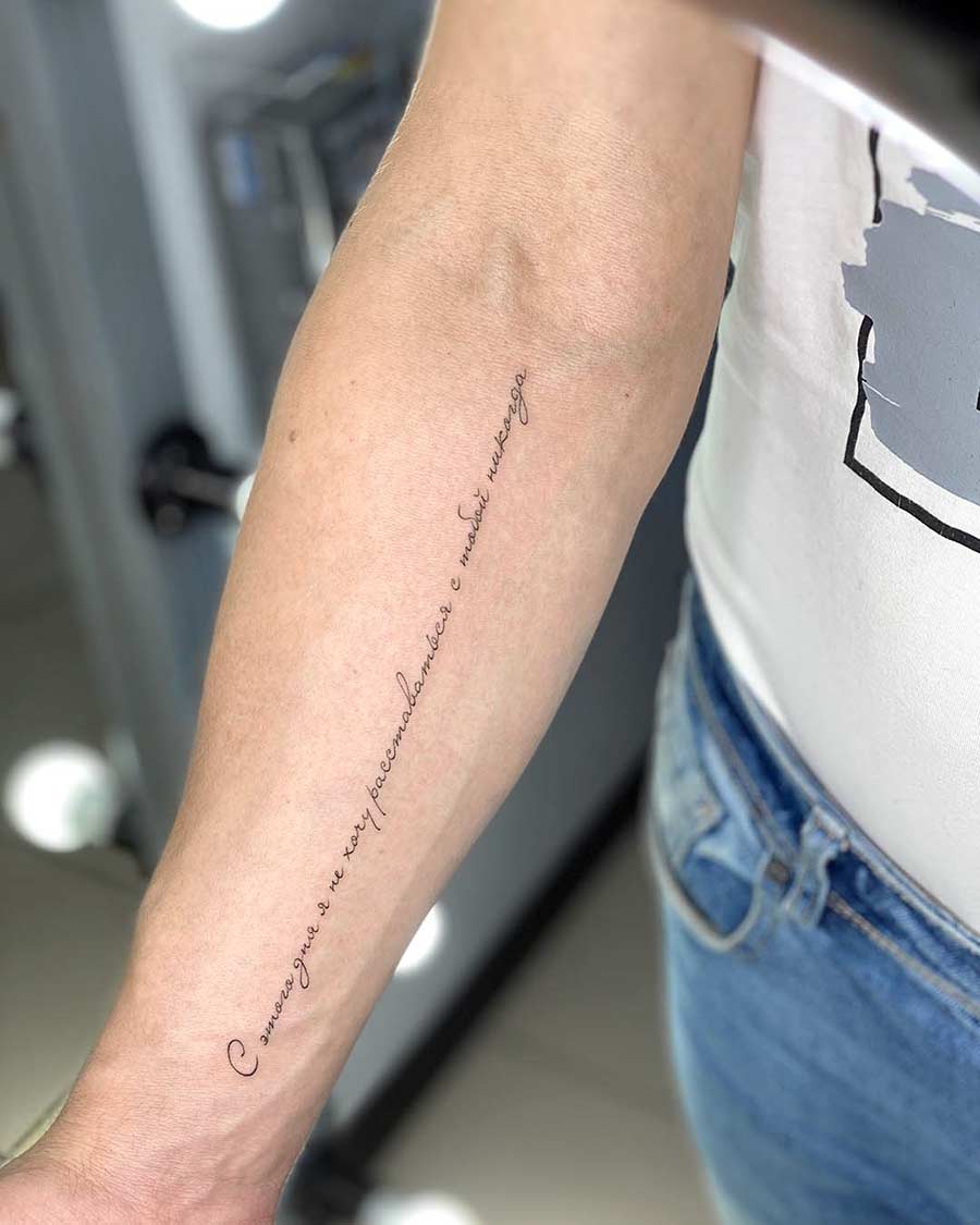 Close-up of a forearm with a delicate, vertical tattoo in Russian script that reads, "С этого дня я не хочу расставаться с тобой никогда" (From this day, I never want to part with you). The skin is fair, and the tattoo is in a fine, elegant font.