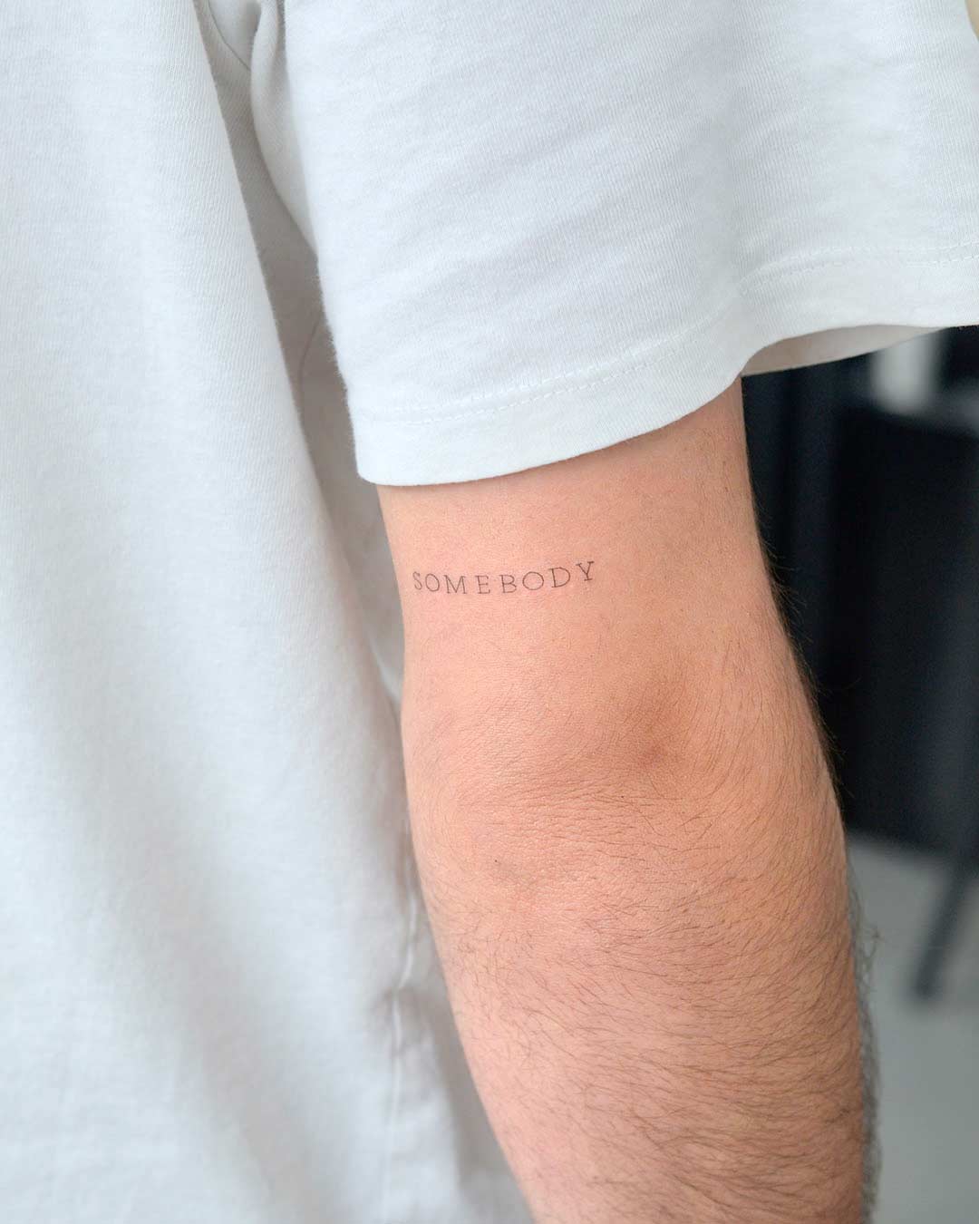 tattoo script lettering on the hand fineline somebody