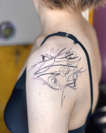 A minimalist line art tattoo on a woman's shoulder, featuring abstract shapes and flowing lines. The black ink design showcases a unique, abstract tattoo style, perfect for those seeking a modern look. done by artists in our fine line tattoo studio Canguu Bali