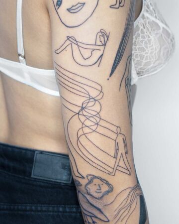 Close-up of an arm featuring an abstract tattoo design. The black line art includes various figures, swirling lines, and a face, showcasing a minimalist tattoo style. The person wears a white bra and black jeans. done by artists in our fine line tattoo studio Canguu Bali
