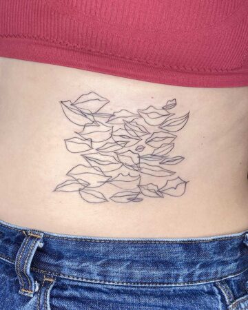 Abstract line art tattoo on lower back above denim jeans Done by tattoo artists in our fine line tattoo studio parlour shop Canggu, Bali