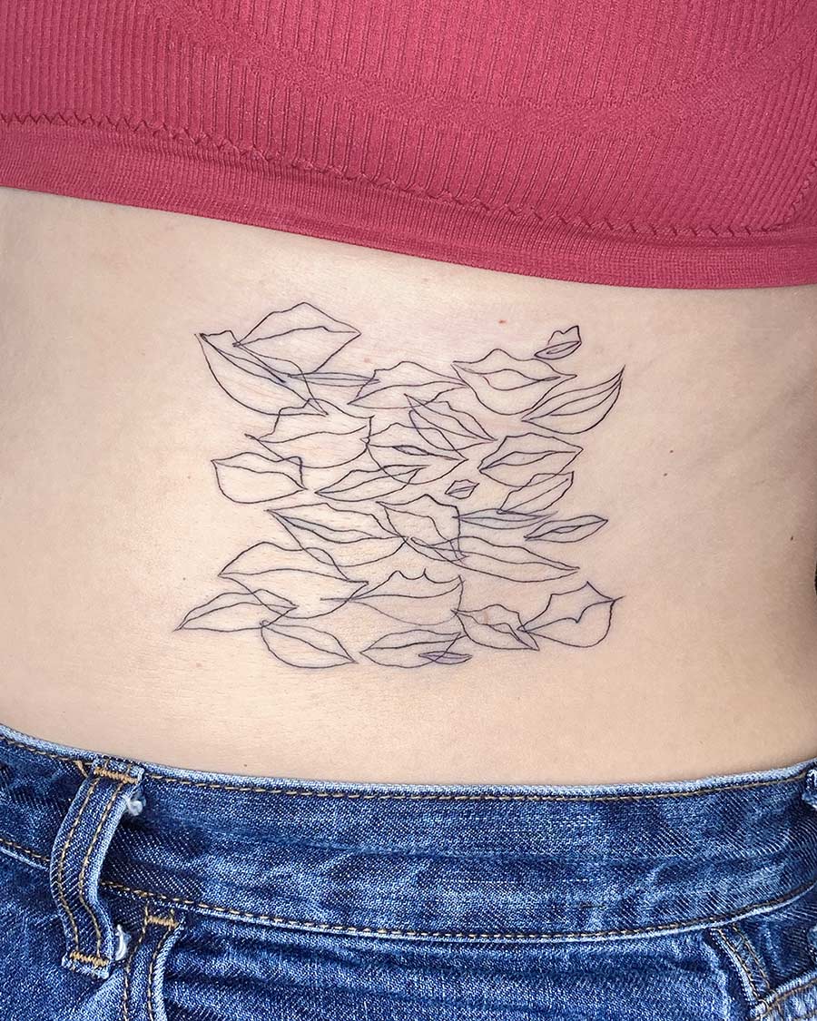 Abstract line art tattoo on lower back above denim jeans Done by tattoo artists in our fine line tattoo studio parlour shop Canggu, Bali