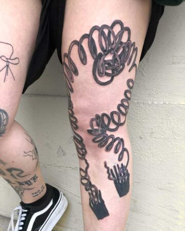 Cable tattoo design on person's leg with detailed loops and plugs Done by tattoo artists in our fine line tattoo studio parlour shop Canggu, Bali