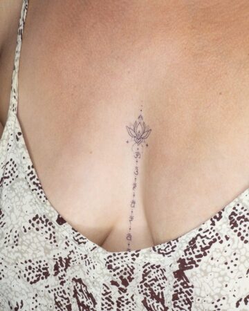 Delicate lotus tattoo with text chacras on the chest sternum by our artists in fine line tattoo studio Canggu Bali