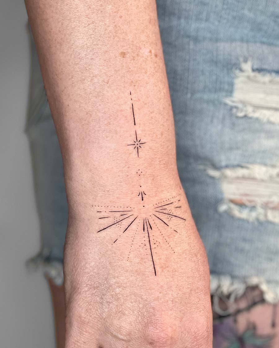 Minimalist starburst tattoo on arm minimalist geometry by our artists in fine line tattoo studio Canggu Bali