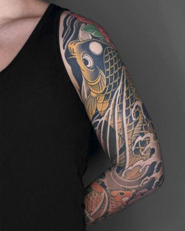 Detailed Japanese koi fish tattoo sleeve on a person's arm. Traditional Irezumi style with vibrant yellow and black scales, water waves, and floral accents. Japanese (Irezumi/Wabori) tattoo artist studio Canggu Bali