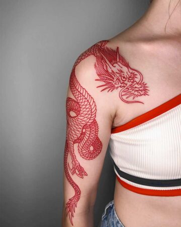 Red ink dragon tattoo gracefully curves down a woman's arm and shoulder. The detailed line work showcases the dragon's scales and fierce expression. Japanese (Irezumi/Wabori) tattoo studio Canggu Bali