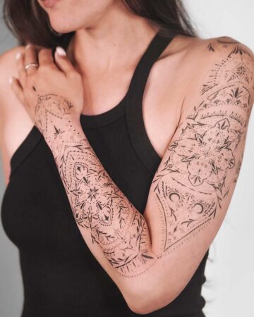 A stunning full-arm ornamental sleeve consisting of interlocking geometric mandalas, floral patterns, and intricate dot-shading that follows the contour of the arm.