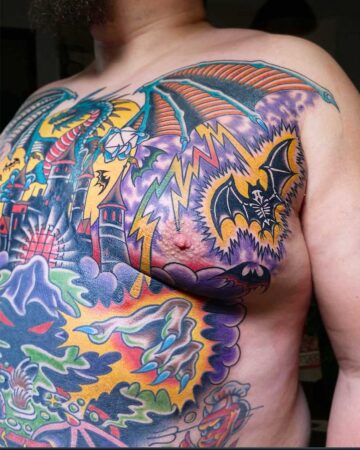 Vivid color traditional tattoo of a dragon and castle on a chest, with bats and lightning. Bali tattoo studio.