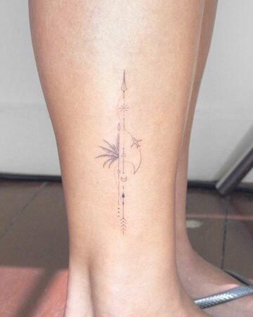 Fine line tattoo on a leg featuring a palm tree, airplane, sun, moon, and arrow symbols in a vertical line. Symbolic spiritual tattoo design. Created by our tattoo artists in Canggu, Bali