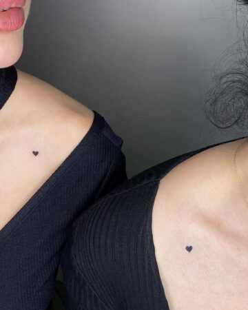 Two friends with matching heart tattoos on their collarbones. A simple and sweet matching tattoo idea. Created by the best expert tattoo artists in Canggu Bali for heart tattoos.