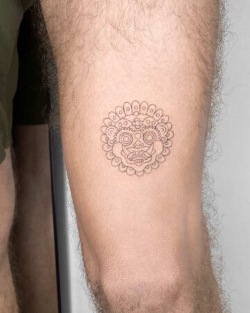 Close-up of a Barong tattoo on a person's arm, featuring intricate line work and a circular design. This Barong tattoo is a striking example of Bali tattoo art. Created by the best expert tattoo artists in Canggu Bali.