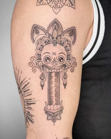 Detailed Barong tattoo on an arm, featuring intricate linework and Balinese design elements. Includes a stylized skull and decorative patterns. Created by the best tattoo artists in Canggu Bali for unique Barong tattoos.