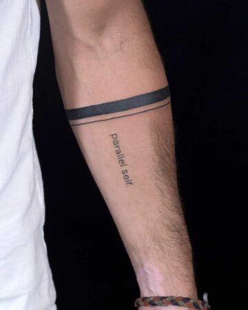 Arm with a bracelet tattoo and the words "parallel self." Simple, modern bracelet design. Bali tattoo created by the best expert tattoo artists in Canggu Bali.