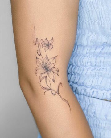 Delicate floral tattoo of lilies and vines on an arm, showcasing fine line tattoo art. Created in the multi style tattoo studio in Canggu Bali, best Bali tattoo studio, Canggu tattoo artist.