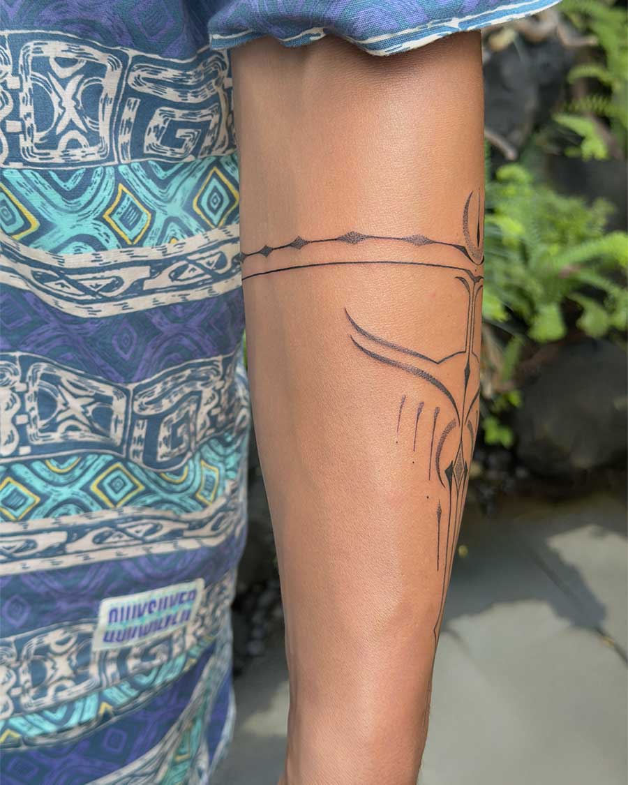 Close-up of a man's forearm showcasing a minimalist ornamental tattoo band and abstract linework. Created in the multi style tattoo studio in Canggu Bali, Bali tattoo. Bali tattoo studio.